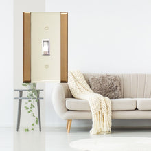 Load image into Gallery viewer, Plastic Ivory with Gold Sided Single Toggle Wall-plate in front of a brightly lit white living room with cream coloured furnishings