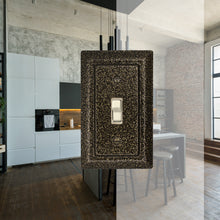 Load image into Gallery viewer, Decorative Metal Weathered Brass Single Toggle wall-plate in fron of a background image of a bright, modern, marble finished kitchen

